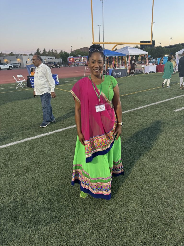 Ronna Green in traditional dress with a neighbor at a cultural celebration