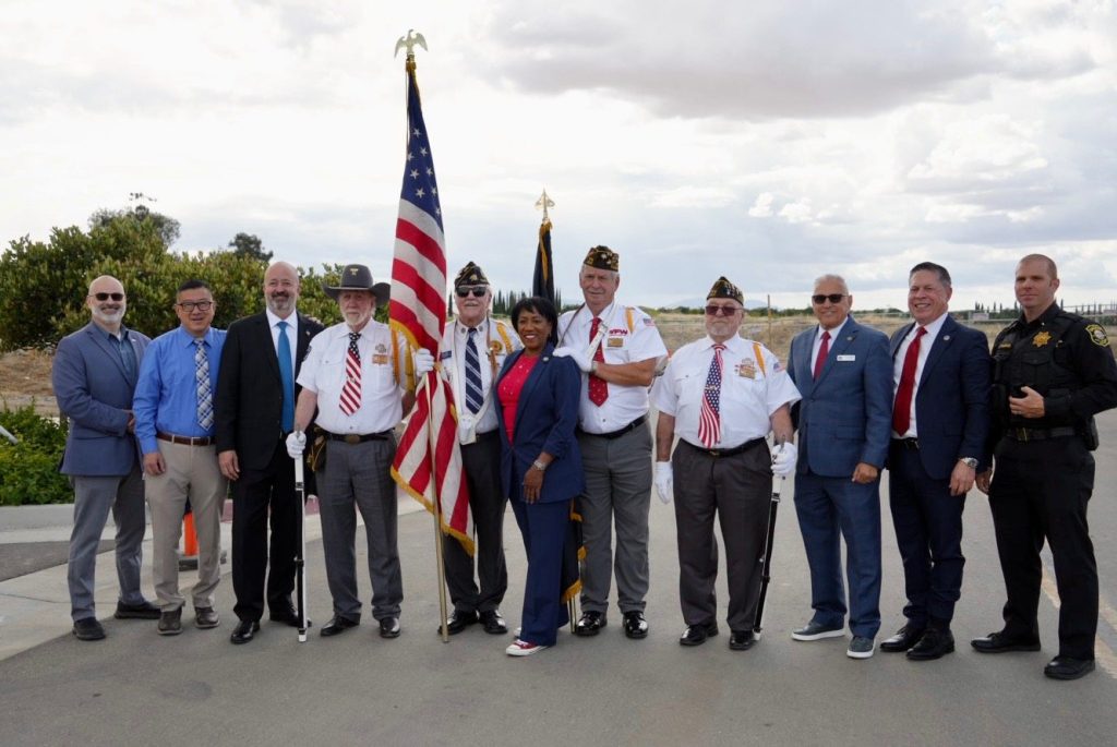 Ronna Green with veterans and officials beside the American flag
